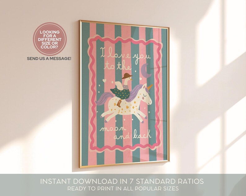 May include: A framed art print with a gold border features a whimsical illustration of a person riding a unicorn. The artwork has a pink and teal striped background with the text "I love you to the moon and back."