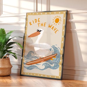 K&ouml;nnte beinhalten: Ein wei&szlig;er Pelikan mit Sonnenbrille reitet auf einem Surfbrett auf einer blauen Welle. Der Text "RIDE THE WAVE" ist in Gelb auf einem beigefarbenen Hintergrund geschrieben.