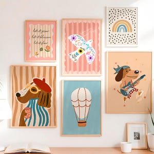 May include: A collection of framed art prints featuring whimsical illustrations. The prints include a dog with glasses and a beret, a dog playing guitar, a hot air balloon, a dove, a rainbow, and text that reads "let it grow, let it blossom, let it flow."