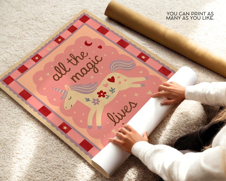 May include: A whimsical poster featuring a unicorn with a floral design and the text "all the magic lives." The poster has a pink and peach color scheme with a red border. A rolled-up poster is next to the poster.