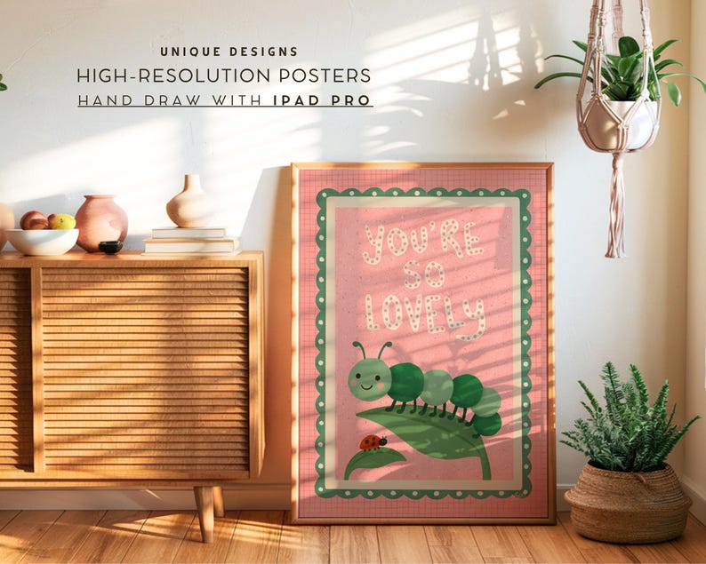 May include: A framed pink poster with the words "YOU'RE SO LOVELY" and a cartoon caterpillar illustration. The poster is surrounded by a green scalloped border. The text "UNIQUE DESIGNS, HIGH-RESOLUTION POSTERS, HAND DRAW WITH IPAD PRO" is at the top.