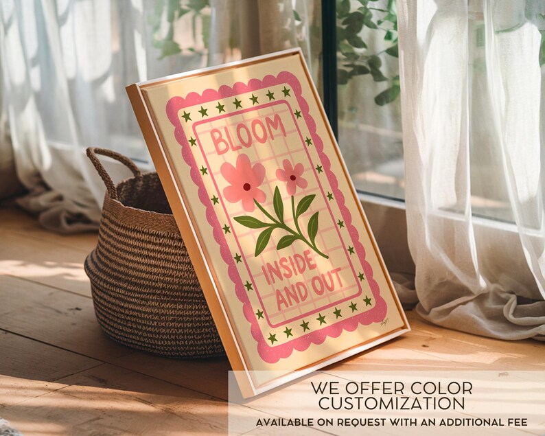 May include: A framed art print with the words "BLOOM INSIDE AND OUT" in a pink and green floral design. The artwork is in a light-colored frame and is propped up next to a woven basket. The text "WE OFFER COLOR CUSTOMIZATION" is at the bottom.