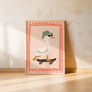 Puede incluir: Una impresión artística enmarcada que presenta un ganso de dibujos animados con gafas de sol y un sombrero verde, montando en monopatín. La obra de arte tiene un fondo rosa con un borde decorativo y está sobre una pared neutra y suelo de madera.