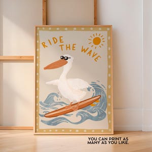 K&ouml;nnte beinhalten: Ein wei&szlig;er Pelikan mit Sonnenbrille surft auf einer blauen Welle mit einem gelben Surfbrett. Der Text "RIDE THE WAVE" ist in gelben Buchstaben auf einem beigefarbenen Hintergrund geschrieben.