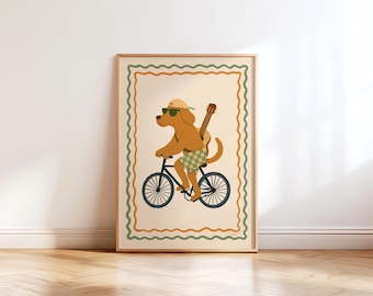 May include: A framed art print featuring a cartoon dog riding a bicycle. The dog wears sunglasses, a cap, and shorts, with a guitar strapped to its back. The artwork has a cream background with a decorative border in green and orange.