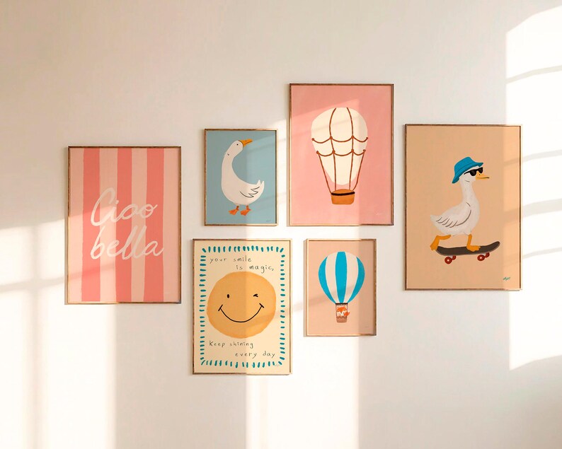 May include: A collection of framed art prints featuring whimsical illustrations. The prints include a pink striped design with the words "Ciao Bella", a goose, hot air balloons, and a smiley face with the text "Your smile is magic".
