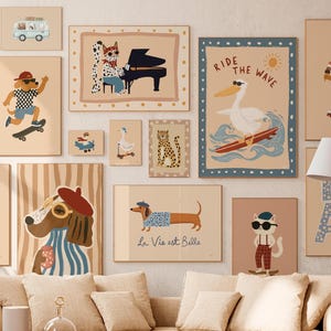 Puede incluir: Una colección de láminas artísticas enmarcadas con ilustraciones de animales caprichosas. La obra de arte incluye un perro tocando el piano, un pelícano surfeando y un perro salchicha con el texto "La Vie est Belle". La paleta de colores es suave y apagada.