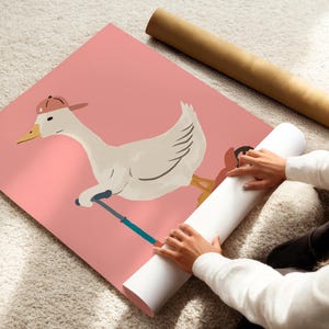 Pu&ograve; includere: Un poster rosa con un'illustrazione stravagante di un'oca con un berretto da baseball e uno scooter. L'oca &egrave; bianca con becco giallo e zampe arancioni. Un poster arrotolato &egrave; accanto al poster rosa.