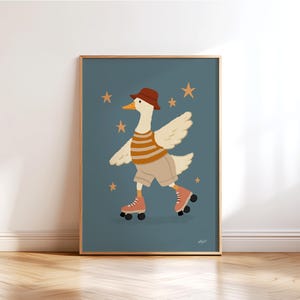 Puede incluir: Impresión artística enmarcada que presenta un ganso de dibujos animados con sombrero marrón, camisa a rayas, pantalones cortos y patines. El ganso está sobre un fondo verde azulado con estrellas doradas. La obra de arte está enmarcada en un marco de madera marrón claro.