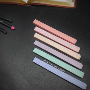 May include: Six pastel-colored highlighter pens with the words "UNWAVERING GRACE" printed on the bottom of the blue pen.