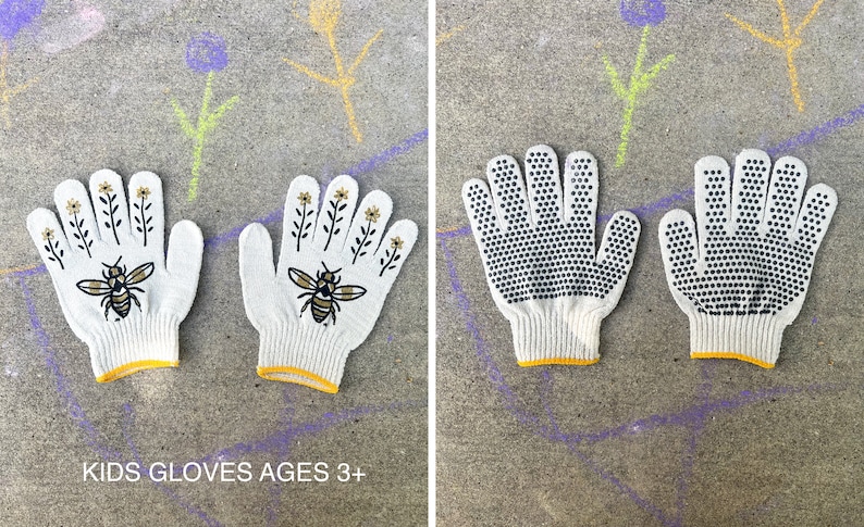 Puede incluir: Un par de guantes de trabajo de algod&oacute;n blanco con ribete amarillo. Un guante tiene un dise&ntilde;o de abeja y flores, el otro tiene puntos negros para agarre. El texto "KIDS GLOVES AGES 3+" est&aacute; impreso debajo de los guantes.
