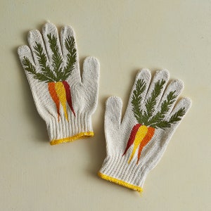 K&ouml;nnte beinhalten: Ein Paar wei&szlig;e Baumwoll-Gartenhandschuhe mit einem gr&uuml;nen und orangefarbenen Karotten-Design.