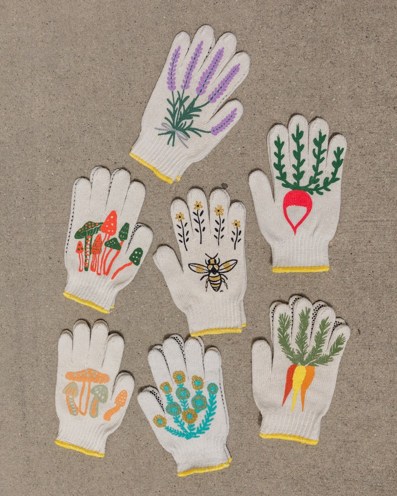 May include: Set of six white cotton gardening gloves with different floral and nature-themed designs. The designs include lavender, a bee, mushrooms, carrots, and flowers.