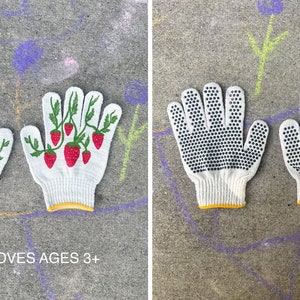 Puede incluir: Dos pares de guantes de trabajo de algod&oacute;n blanco. Un par tiene un dise&ntilde;o de fresa y el otro par tiene puntos negros. Los guantes tienen un ribete amarillo y el texto "KIDS GLOVES AGES 3+" est&aacute; impreso debajo de los guantes.
