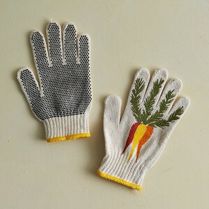 K&ouml;nnte beinhalten: Ein Paar Gartenhandschuhe. Ein Handschuh ist wei&szlig; mit schwarzen Punkten und der andere ist wei&szlig; mit einem gr&uuml;nen Karottenmuster.
