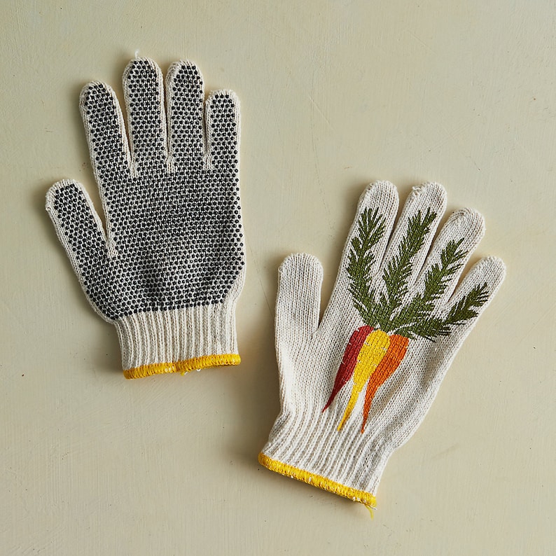 K&ouml;nnte beinhalten: Ein Paar Gartenhandschuhe. Ein Handschuh ist wei&szlig; mit schwarzen Punkten und der andere ist wei&szlig; mit einem gr&uuml;nen Karottenmuster.