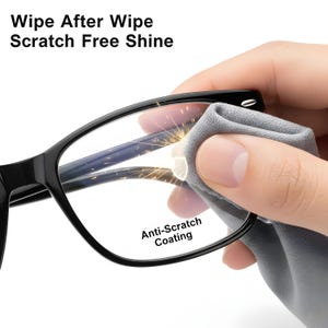 May include: Black eyeglasses being cleaned with a gray microfiber cloth. The glasses have a rectangular frame and clear lenses. Text on the image reads "Wipe After Wipe Scratch Free Shine" and "Anti-Scratch Coating".