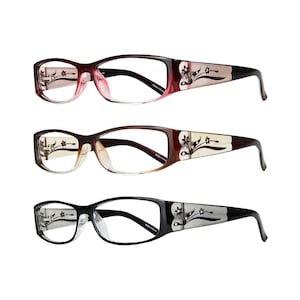 May include: Three pairs of eyeglasses with brown, black, and red frames. Each pair has a floral design on the side of the frame. The glasses have clear lenses.