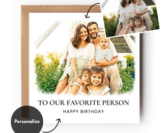 May include: A square greeting card with a watercolour-style family portrait featuring two adults and two children sitting in greenery. The text reads TO OUR FAVORITE PERSON HAPPY BIRTHDAY. A small circular black icon with the word Personalise is included.