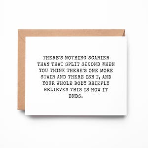 May include: A white greeting card with black typewriter-style text that reads: THERE'S NOTHING SCARIER THAN THAT SPLIT SECOND WHEN YOU THINK THERE'S ONE MORE STAIR AND THERE ISN'T, AND YOUR WHOLE BODY BRIEFLY BELIEVES THIS IS HOW IT ENDS. Includes a brown envelope.