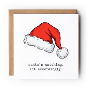 May include: A square greeting card featuring a hand-drawn illustration of a red Santa hat with a white fur trim and pom-pom. Below the hat, the text is printed in a black typewriter-style font reading: santa's watching. act accordingly.