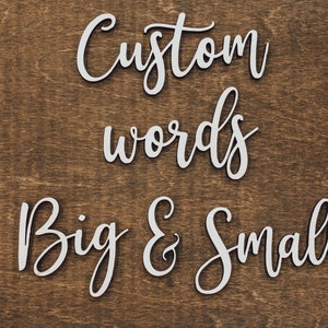 Artisan birch unfinished wood script words that say "custom words big & small" on a dark walnut stained background