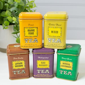 May include: A collection of six vintage tea tins in various colors, including orange, yellow, brown, purple, and green. Each tin features a label with tea type names like "Orange Pekoe" and "Imperial Gunpowder." The tins are labeled with the brand name and net weight.