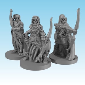 Può includere: Tre statuette in miniatura di arcieri scheletrici grigi su basi circolari. Ogni figura presenta una testa a teschio, una gabbia toracica scheletrica e abiti logori, con un arco e una faretra, posizionate in diverse posture di combattimento.