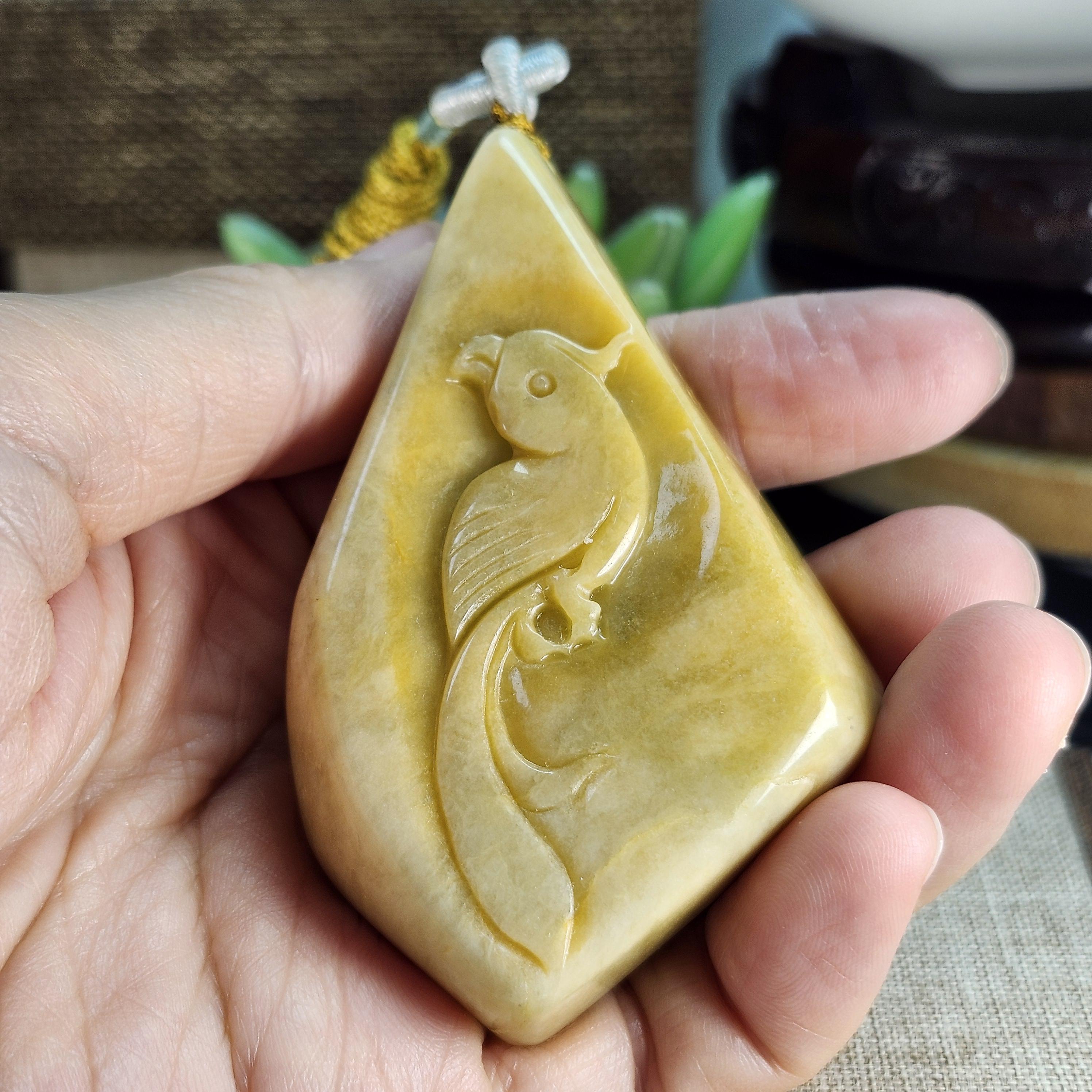 大きな未処理の天然翡翠の原石にオウムが綺麗に彫られており、美しい