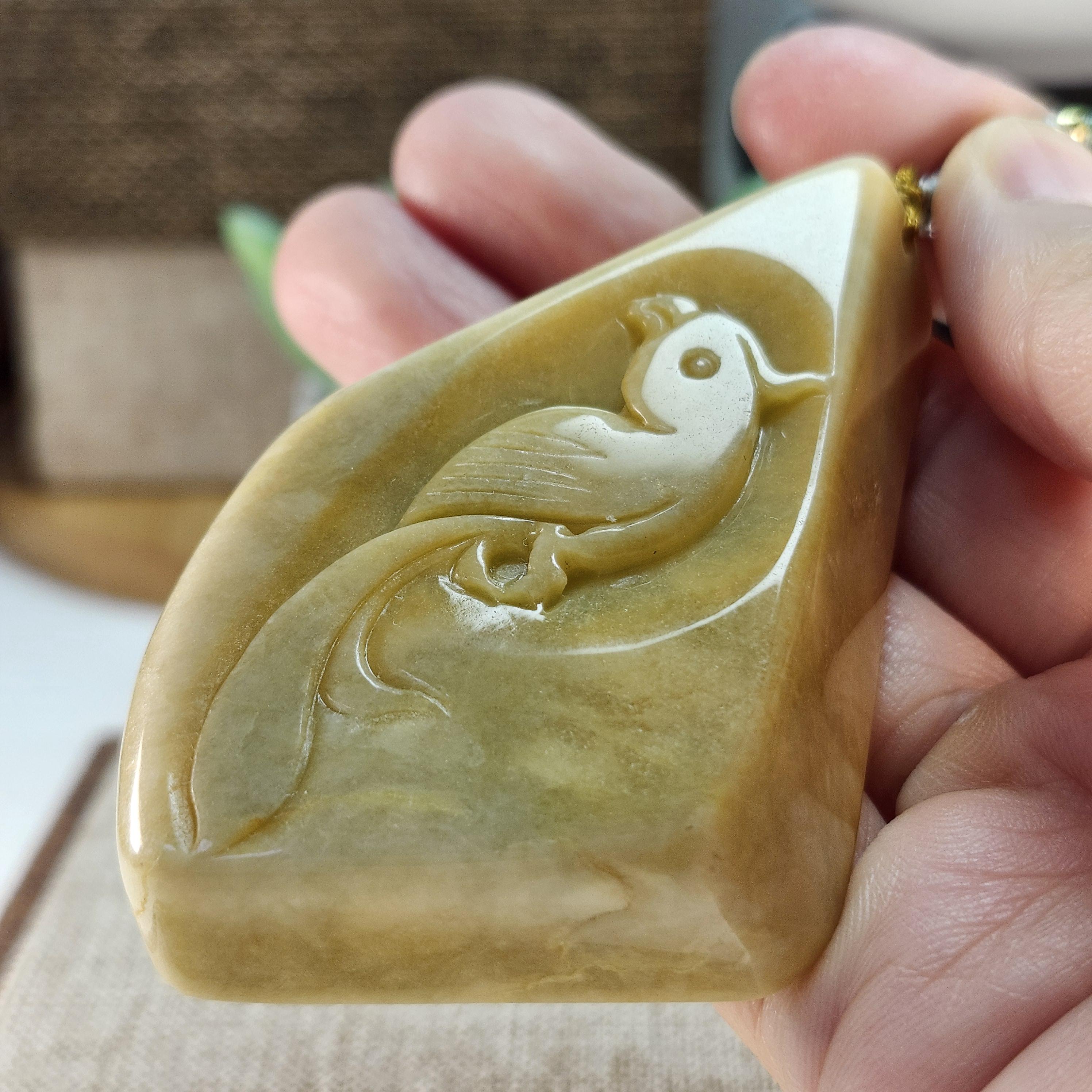 大きな未処理の天然翡翠の原石にオウムが綺麗に彫られており、美しい