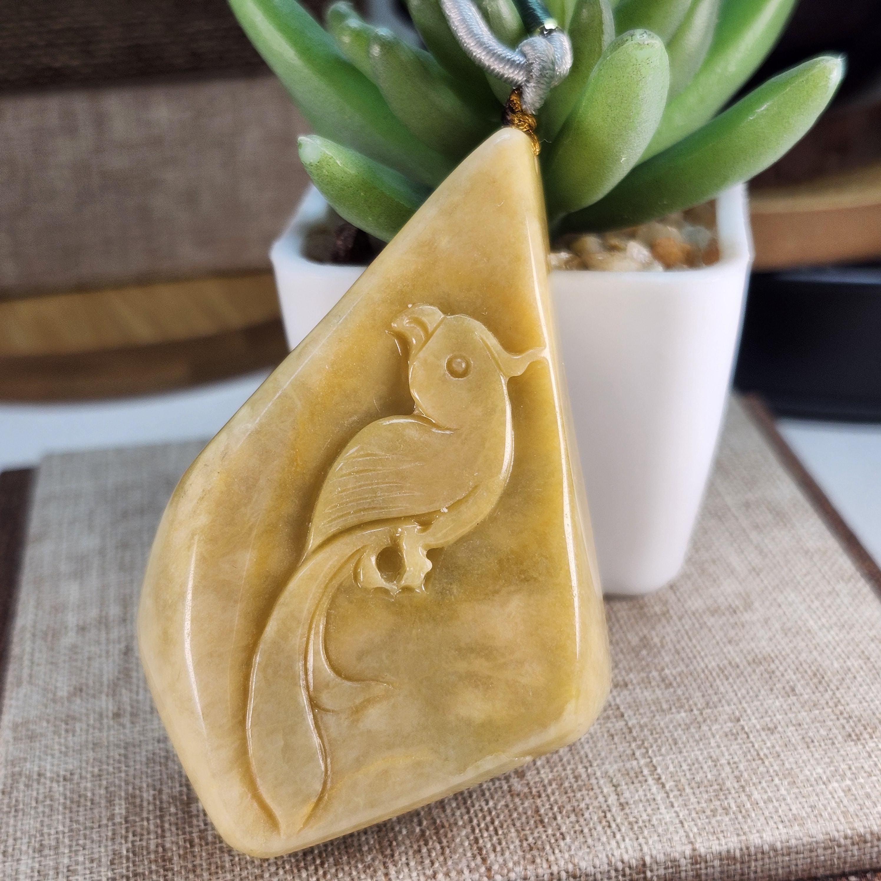 大きな未処理の天然翡翠の原石にオウムが綺麗に彫られており、美しい