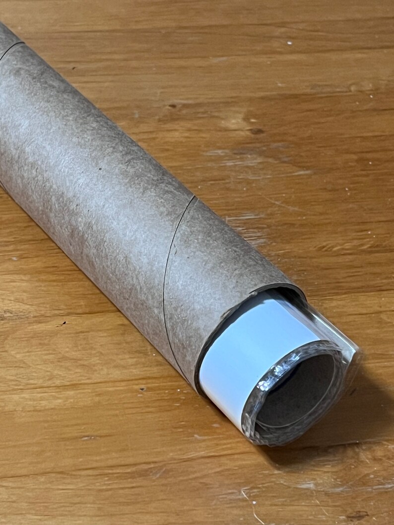 May include: A rolled up poster or print with a brown paper tube and a white backing. The poster is wrapped in clear plastic.