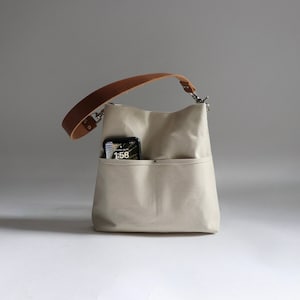 Hobo Bag with two front pockets and Tan leather strap. Natural color canvas purse in medium size.