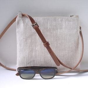 Natural linen crossbody bag with zippered closure and adjustable leather strap.  Simple, casual style small crossbody purse.