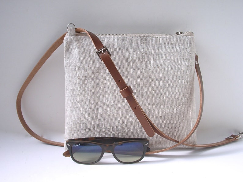 Natural linen crossbody bag with zippered closure and adjustable leather strap.  Simple, casual style small crossbody purse.