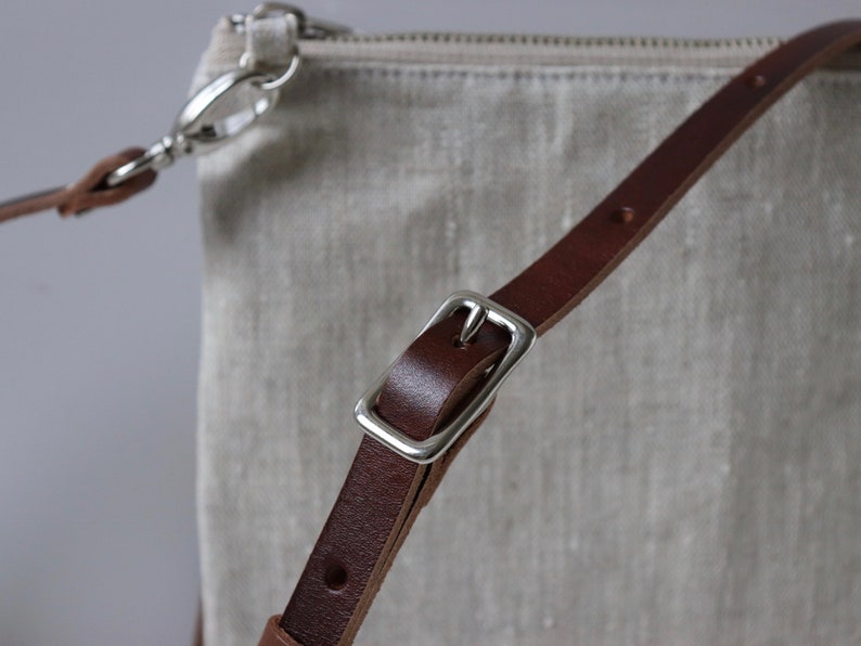 Close up detail of adjustable leather crossbody strap.