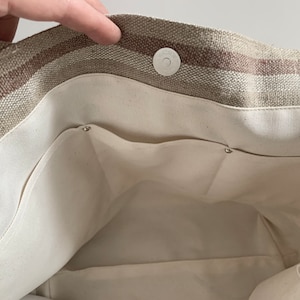 Interior of woven beach tote showing natural lining and slip pockets.