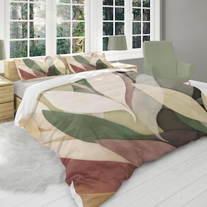 May include: A bed with a duvet cover and pillowcases featuring a leaf design in shades of green, brown, and beige. The bed is in a room with a window, a wooden nightstand, and a lamp.