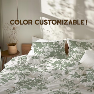 May include: White bedding set with a green floral pattern. The set includes a duvet cover and pillowcases. The text "COLOR CUSTOMIZABLE!" is displayed across the top of the image. The bedding is on a wooden bed frame.