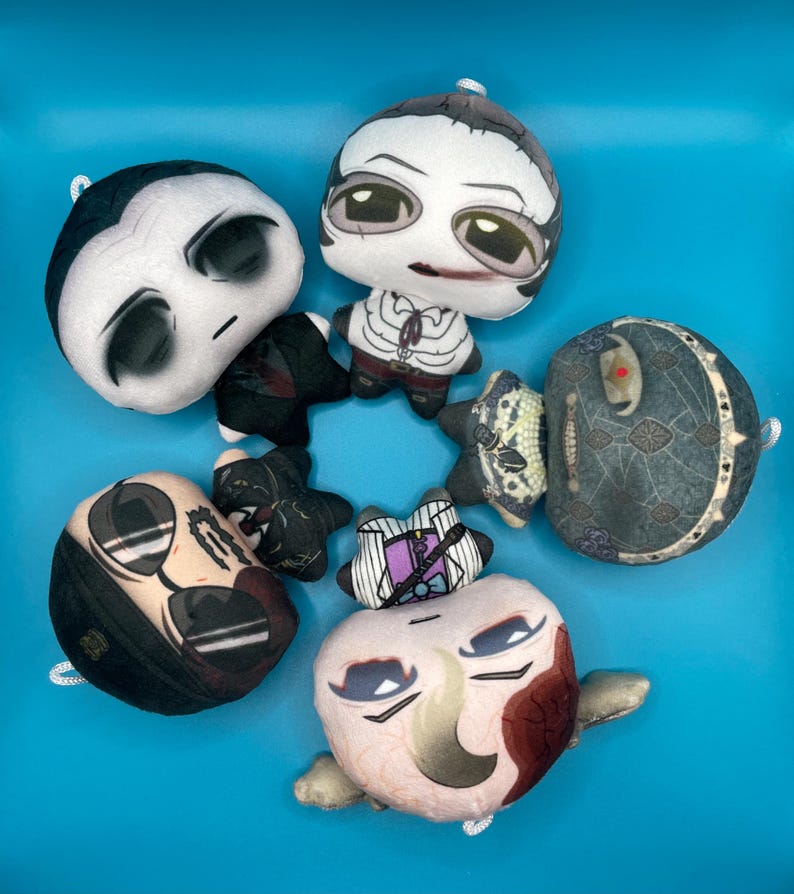 May include: A collection of plush dolls with various character designs. The dolls feature detailed facial expressions and are made of soft fabric. The color palette includes black, white, and shades of beige and brown, set against a bright blue background.