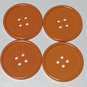 May include: Four orange plastic buttons with four holes each.