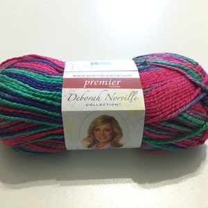 May include: A skein of Premier Yarns Deborah Norville Collection yarn in a pink, green, and purple colorway. The yarn is wrapped around a white label with the Premier Yarns logo and the text "Deborah Norville Collection".