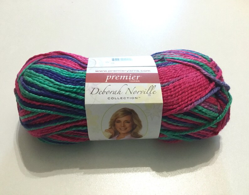 May include: A skein of Premier Yarns Deborah Norville Collection yarn in a pink, green, and purple colorway. The yarn is wrapped around a white label with the Premier Yarns logo and the text "Deborah Norville Collection".