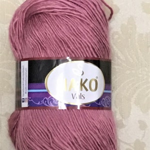 May include: A skein of pink yarn with a label that reads "Nako Vals".