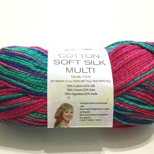 May include: A skein of Cotton Soft Silk Multi yarn in a pink, green, and purple color combination. The yarn is 126 yards and 2.5 ounces. The label states that the yarn is 78% cotton and 22% silk.