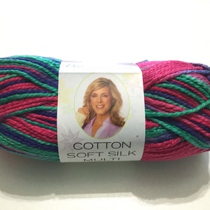 May include: A skein of Cotton Soft Silk yarn in a multi-colored pattern of pink, green, and purple. The label reads "Cotton Soft Silk Multi".