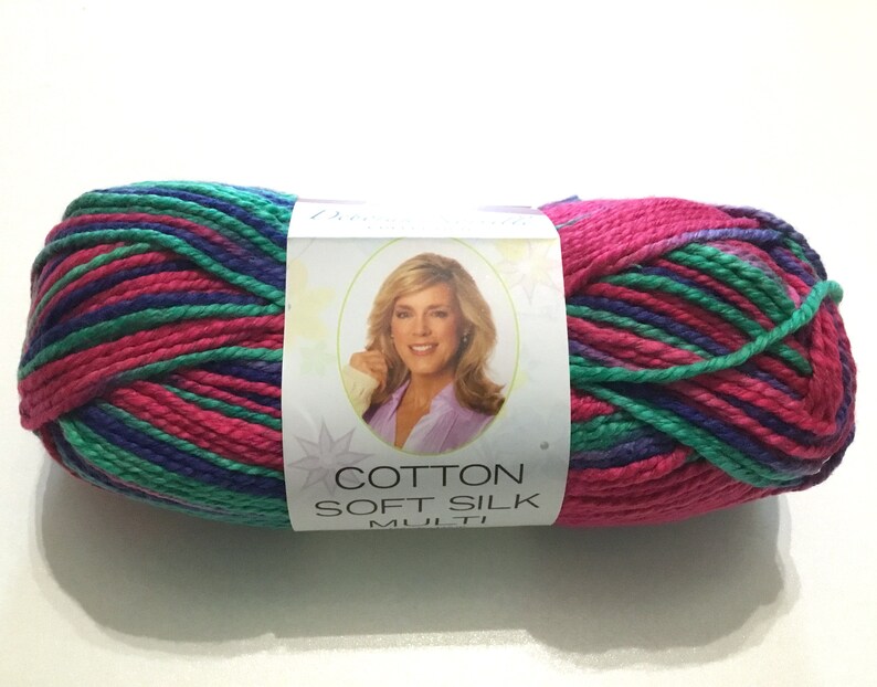 May include: A skein of Cotton Soft Silk yarn in a multi-colored pattern of pink, green, and purple. The label reads "Cotton Soft Silk Multi".