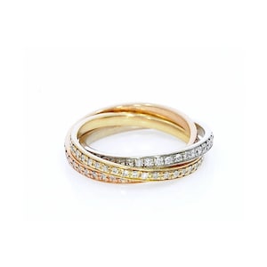Puede incluir: Un anillo entrelazado tricolor que presenta tres bandas en oro amarillo, rosa y blanco. La banda de oro blanco está engastada con pequeñas piedras redondas transparentes, mientras que las bandas de oro amarillo y rosa tienen un acabado pulido.