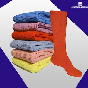 May include: A stack of six pairs of colorful socks in various shades of blue, pink, orange, and yellow. The socks are made of a soft, textured fabric. One pair of orange socks is shown on a foot.