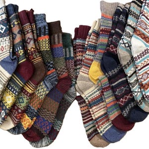 May include: A collection of colorful, patterned socks. The socks feature various designs, including geometric shapes, stripes, and traditional knit patterns. The color palette includes blues, reds, greens, and creams. These socks are likely made of a warm, comfortable material.